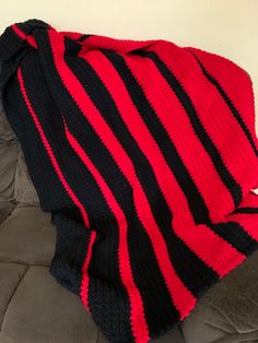 a black and red blanket sitting on top of a couch