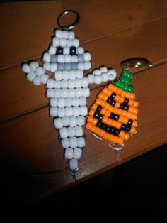 an orange and black beaded pumpkin keychain next to a bottle opener