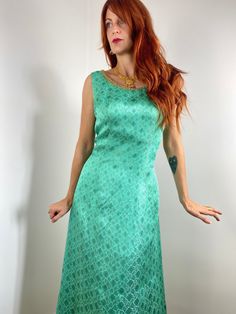 "Gorgeous vintage 60s/70s formal sleeveless maxi dress in a light turquoise verging on mint, lurex brocade fabric with decorative gold metal ribbon accents at the bottom and neckline. This is truly a one-of-a-kind piece as it's handmade and luxurious! Shown here on a size FR 36/UK 8/US 2/S model with a 172cm / 5'8\" height with slight adjustments smaller at the bust/waist. This dress would best fit a FR 38-40 / UK 10-12 / M but please verify all measurements to be sure.  Bust (Armpit to Armpit): 45cm - 17.75in  Waist: 40.5cm - 16in Hips: 53cm  - 21in Overall Length: 140cm - 55in Condition: Very good - no flaws to note Material: Mid weight brocade type material typical from this era - has a sheen Closure/Details: metal zipper up side, decorative lurex ribbon at neck and bottom  Accessories Vintage Sleeveless Festive Dress, Festive Sleeveless Vintage Dress, Festive Vintage Sleeveless Dress, Festive Turquoise Dress For Party, Festive Turquoise Party Dress, Brocade Dress, Brocade Dresses, Brocade Fabric, Light Turquoise