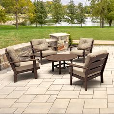 a patio with chairs, tables and a fire pit