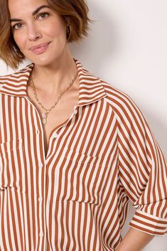 A drawstring hem adds a unique flair to this classic button-down by LNA. Crafted in lightweight fabric, this striped top features a collared neckline, relaxed fit, and two chest pockets. Pair with your favorite cutoffs and sandals for a polished summer look. Trendy Striped Blouse For Daywear, Trendy Striped Collared Blouse, Chic Striped Blouse With Shirttail Hem, Casual Shirt With Vertical Stripes And Shirttail Hem, Casual Tops With Vertical Stripes And Shirttail Hem, Casual Striped Blouse With Shirttail Hem, Casual Striped Blouse For Daywear, Collared Striped Shirt For Daywear, Casual Vertical Stripes Blouse For Fall