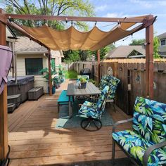 a patio with blue and green chairs under an awning next to a wooden deck