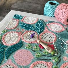 two balls of yarn sitting on top of a table next to scissors and knitting needles