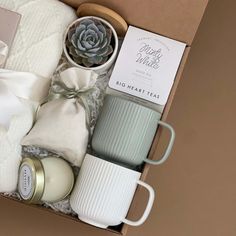 an open box with candles, mugs and other items