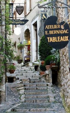 an alleyway with stone steps leading up to the entrance and sign for atelier e bernac tableaux