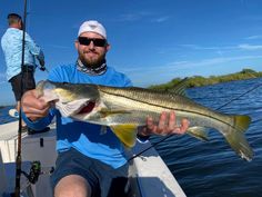 a man on a boat holding a large fish