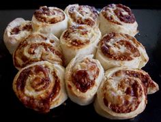 a pile of cinnamon rolls sitting on top of a black counter