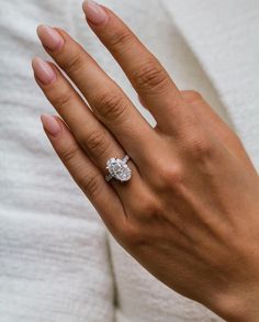 a woman's hand with a diamond ring on it