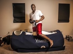 a man standing on top of a bag in a room with other items around him