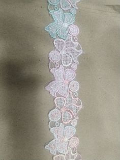 the lace is white with pink and blue flowers on it, along with two rows of hearts