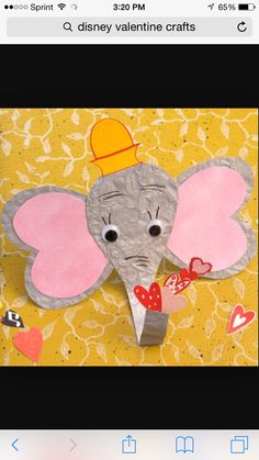 an elephant made out of paper on top of a yellow background with hearts and flowers