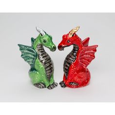 two red and green dragon figurines sitting next to each other