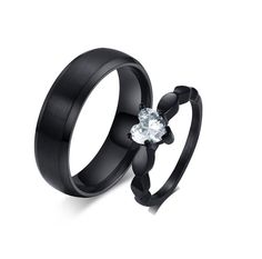 two black wedding bands with a heart shaped diamond in the center and free engraving on each band