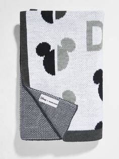 the mickey mouse blanket is folded on top of a white surface with black and gray dots