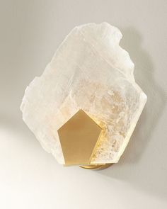 a wall light that is on the side of a wall with a rock in front of it