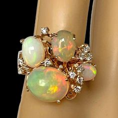 Stunning Top-Quality Opal & Diamond Ring in 18K Gold Opal - Top Quality Fiery Opal 12 CTs total 4 individual Oval Stones  Full Color Play - Reds, Greens, Orange, Yellows Great Cut Cabochons Excellent Color Saturations  1.0 CTs Natural White Diamonds Scattered throughout the Ring & Mounting  VVS n Quality G in Color Excellent Cuts Round Brilliant Cuts 18K Gold Handmade Mounting 11g October Birthstone Ring, Opal Diamond Ring, October Birthstone Rings, Dainty Band, Vvs Diamond, Morganite Diamond, Ring Mountings, Color Play, Custom Pendants