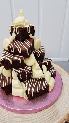 a stack of brownies sitting on top of a purple plate covered in white frosting