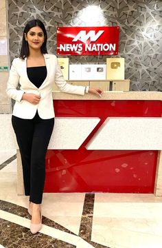 a woman standing in front of a news station counter with her hands on her hips