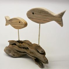 two wooden fish on top of a piece of driftwood