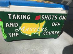 a green and white cooler with the words taking shots on and masters course painted on it