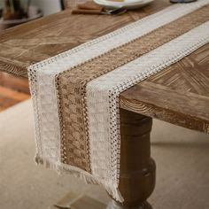 a wooden table topped with a plate of food and a white lace runner on top of it