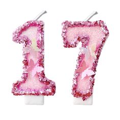 the number seven is made out of pink and white glitter with flowers on it's sides