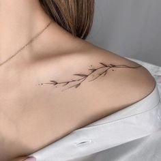 the back of a woman's shoulder with an arrow tattoo