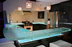 a modern kitchen with an island counter and stools in front of the bar area