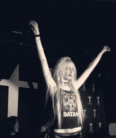 a woman standing on top of a stage with her arms in the air