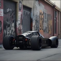 a car that is sitting on the ground in front of a building with graffiti all over it