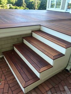 the steps are made out of wood and have white trim on them, along with brick pavers