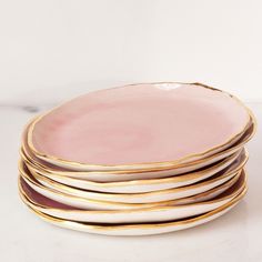 a stack of pink and gold plates sitting on top of each other