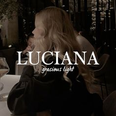 a woman sitting at a table with a glass of wine in front of her and the words luciana across it