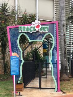 the entrance to fracta pet is decorated in pink, blue and green with a cat's head on it