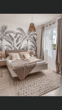 a bedroom with a large bed and palm trees on the wall behind it is decorated in neutral colors