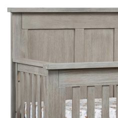 a wooden crib with white sheets on the bottom and wood paneling around it