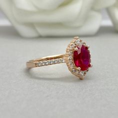 This beautiful ring is made from genuine 925 sterling silver with rose gold plating. Engagement Ring details- -The Main stone is an oval cut 8mm by 6mm Lab Created Ruby Stone -Side stones are Round 1.2MM-2MM simulated diamonds -Ring is cast in solid 925 sterling silver with rose gold plating (yellow gold and rhodium plated also available, please check the drop down menu for more options) -The Total face height of the ring measures 10mms and the band width measures 1.4mms -Each ring is handmade a Rose Gold Ruby Ring With Halo Design, Fine Jewelry Rose Gold Ruby Ring With Halo Design, Rose Gold Ruby Ring Oval, Classic Rose Gold Ruby Ring With Halo Setting, Oval Rose Gold Ruby Ring For Anniversary, Rose Gold Ruby Ring With Halo, Rose Gold Ruby Ring With Halo Setting For Anniversary, Classic Rose Gold Ruby Ring For Proposal, Classic Oval Rose Gold Ruby Ring