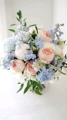 a bouquet of flowers sitting on top of a white table next to a window sill