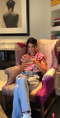 a woman sitting in a chair using her cell phone