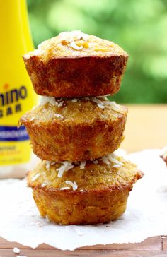 three coconut muffins stacked on top of each other next to a bottle of yogurt