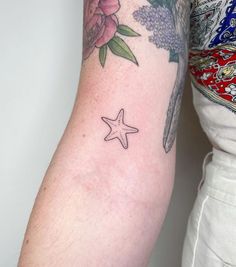 a woman's arm with a star tattoo on the left side of her arm