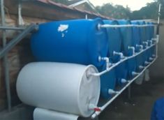 an image of some blue and white water tanks on the side of a building with text that reads simple barrel system collects $ 25 gallons of water