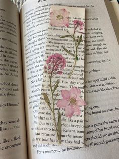 an open book with pink flowers on it