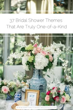 a blue and white vase filled with flowers on top of a table next to pictures