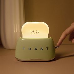 a toaster shaped like a smiling face with the word toast on it's side