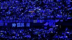 a large crowd of people holding up signs in the dark with chinese characters on them