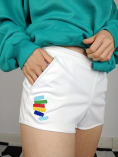 DESCRIPTION The White Tacchini is a 90s vintage gem from Sergio Tacchini. This white tennis shorts has a colorful embroidery and the Sergio Tacchini logo in the front. Labaled as a size 40, estimated to fit like XS-S. This shorts has light stretch and is made in Italy. CONDITION The vintage shorts is in great condition SIZING This vintage shorts is estimated as a size XS-S and labeled as size 40 > please check measurements below Measurements: Waist: 36cm Front till crotch seam: 20cm Hips: 47cm Back: 25cm Model wears size XS/S and is 1m65  MATERIAL 100% polyester BRAND Sergio Tacchini made in Italy 90s rare piece WITH LOVE  All vintage fashion for women are washed and shipped from Berlin with a lot of love Your favourite online vintage clothing shop  The Vintage Takeaway White Summer Tennis Shorts, White Tennis Shorts For Summer, Sporty White Tennis Shorts, Fitted White Tennis Shorts, Casual White Athletic Shorts For Cheerleading, White Sporty Tennis Athletic Shorts, Sporty White Athletic Shorts For Tennis, White Athletic Shorts For Summer Cheerleading, White Athletic Shorts For Cheerleading In Summer