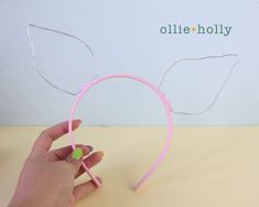 a hand holding a pair of ears made out of plastic