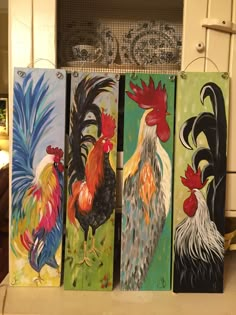 four paintings of roosters are displayed on a countertop in front of a stove