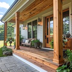 the front porch is covered with wood and has potted plants on either side of it